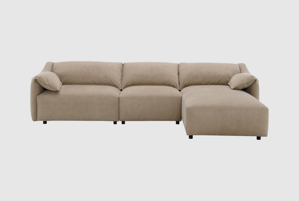 A caramel suede sectional sofa in a bright living room with sunlight grazing the cushions and showing subtle nap shading