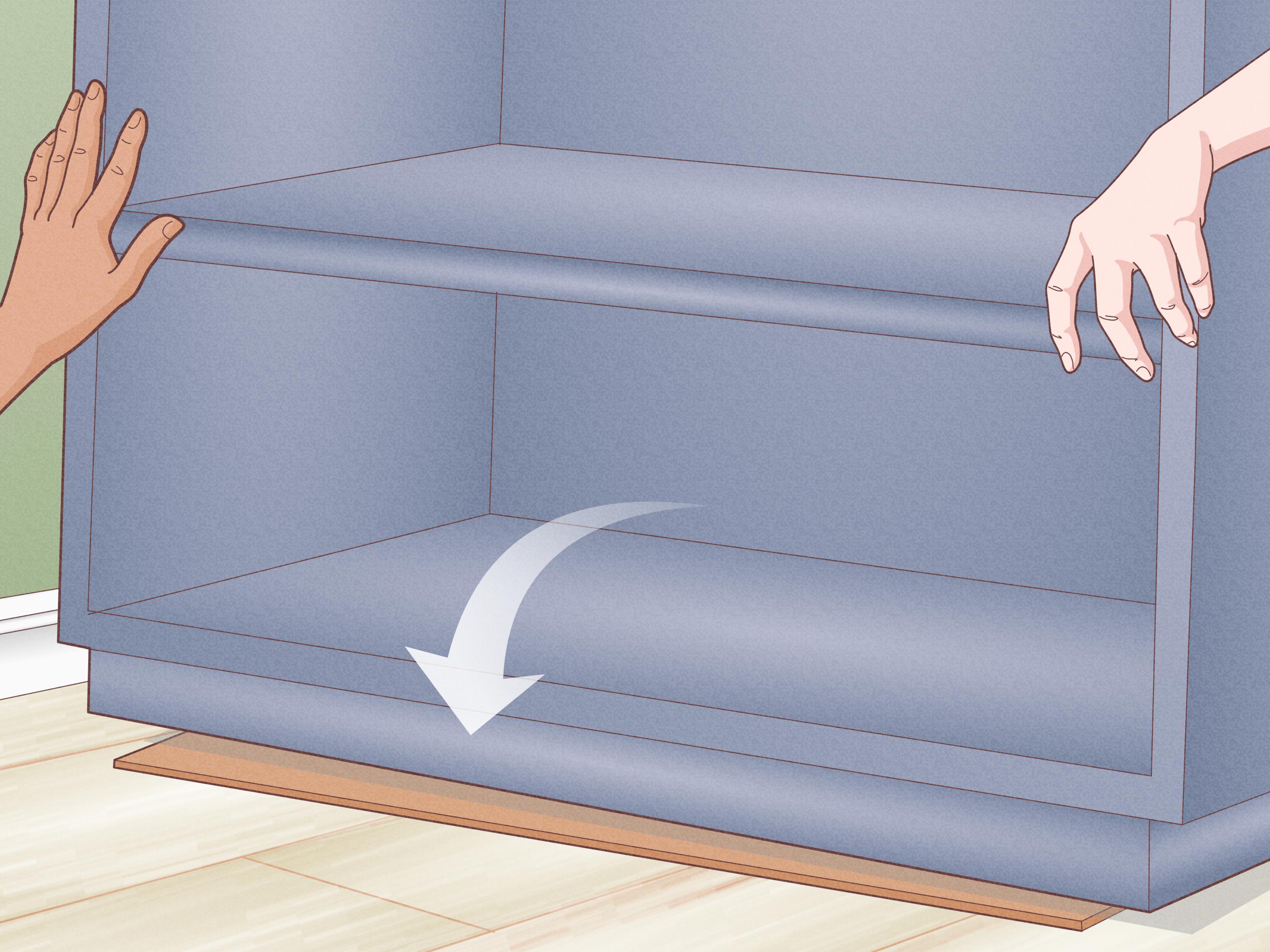 A close-up of a hand using a drill to anchor the top of a tall bookcase into a wall stud with a metal bracket, home interior