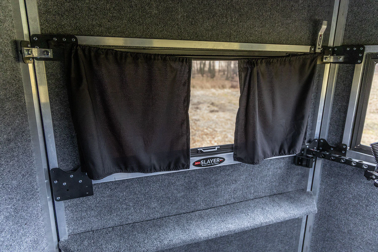 A close-up of a steel casement window in an apartment with a blackout panel neatly secured along the frame, minimal light leaking around the edges, realistic photography style