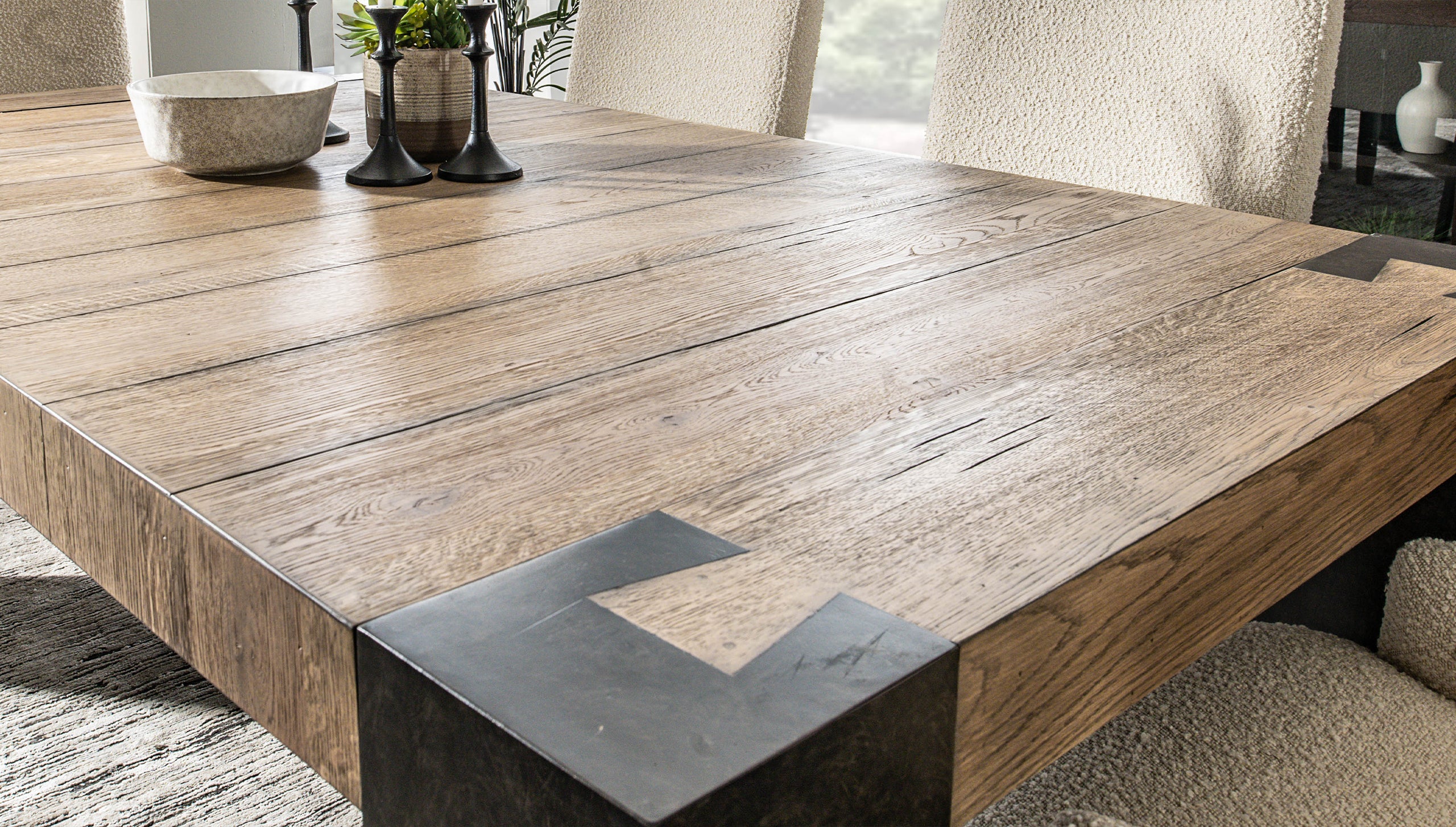 A close-up photo of a cotton swab being used to dab a tiny spot on a navy upholstered sofa arm, with a small glass dish nearby, careful spot-testing setup