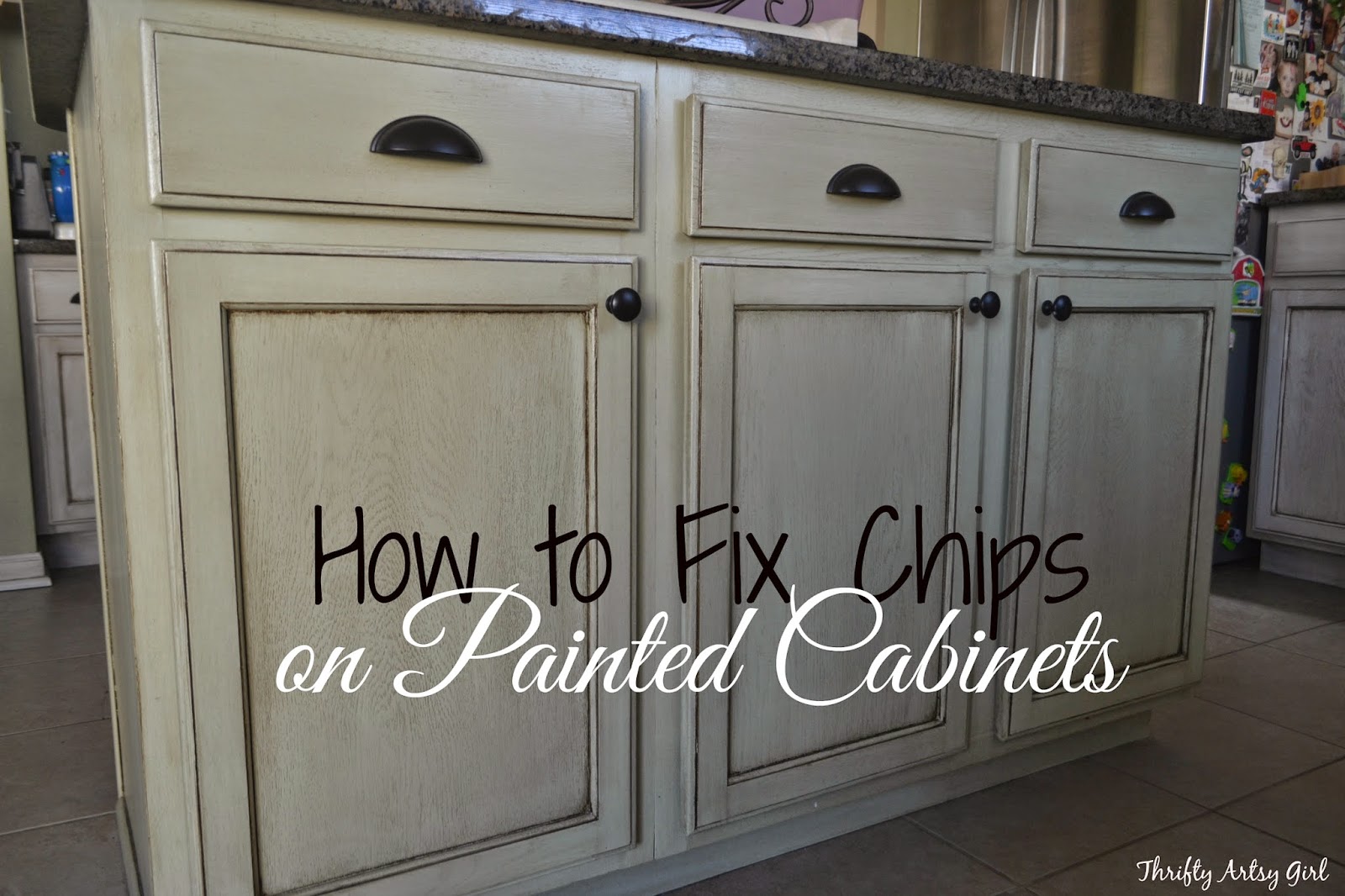 A close-up photo of a hand lightly stippling wet white paint on a cabinet edge with a small makeup sponge to blend a touch-up area