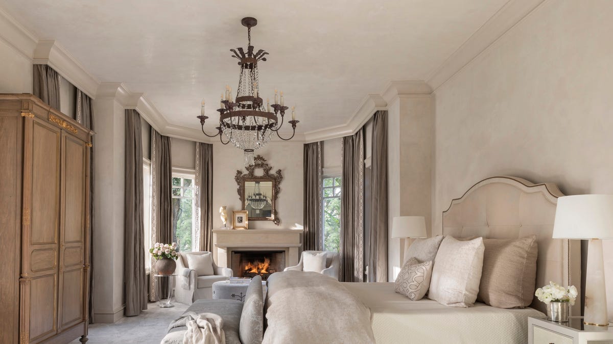 A cozy bedroom with warm bedside lamps and eggshell-painted walls that show a soft, subtle glow without strong reflections, realistic home photography style