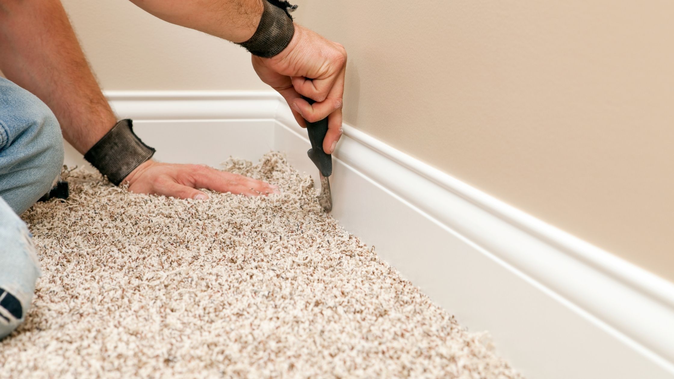 A freshly installed wall-to-wall carpet in an empty apartment room with baseboards visible and a window slightly open letting in daylight