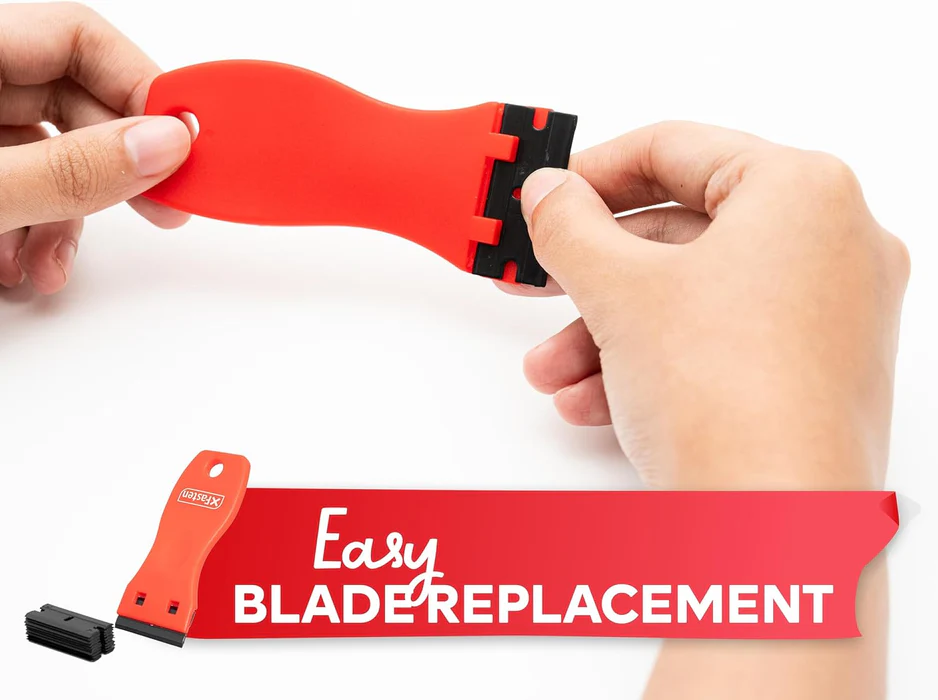 A hand holding an old credit card used as a dull scraper, lifting tiny dried paint flecks from a textured gray upholstered chair seat, close-up photo