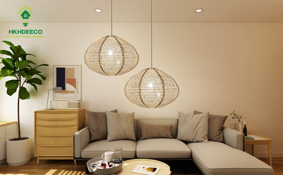 A living room at dusk lit by a table lamp with a fabric shade and a floor lamp, with warm, soft light across the seating area