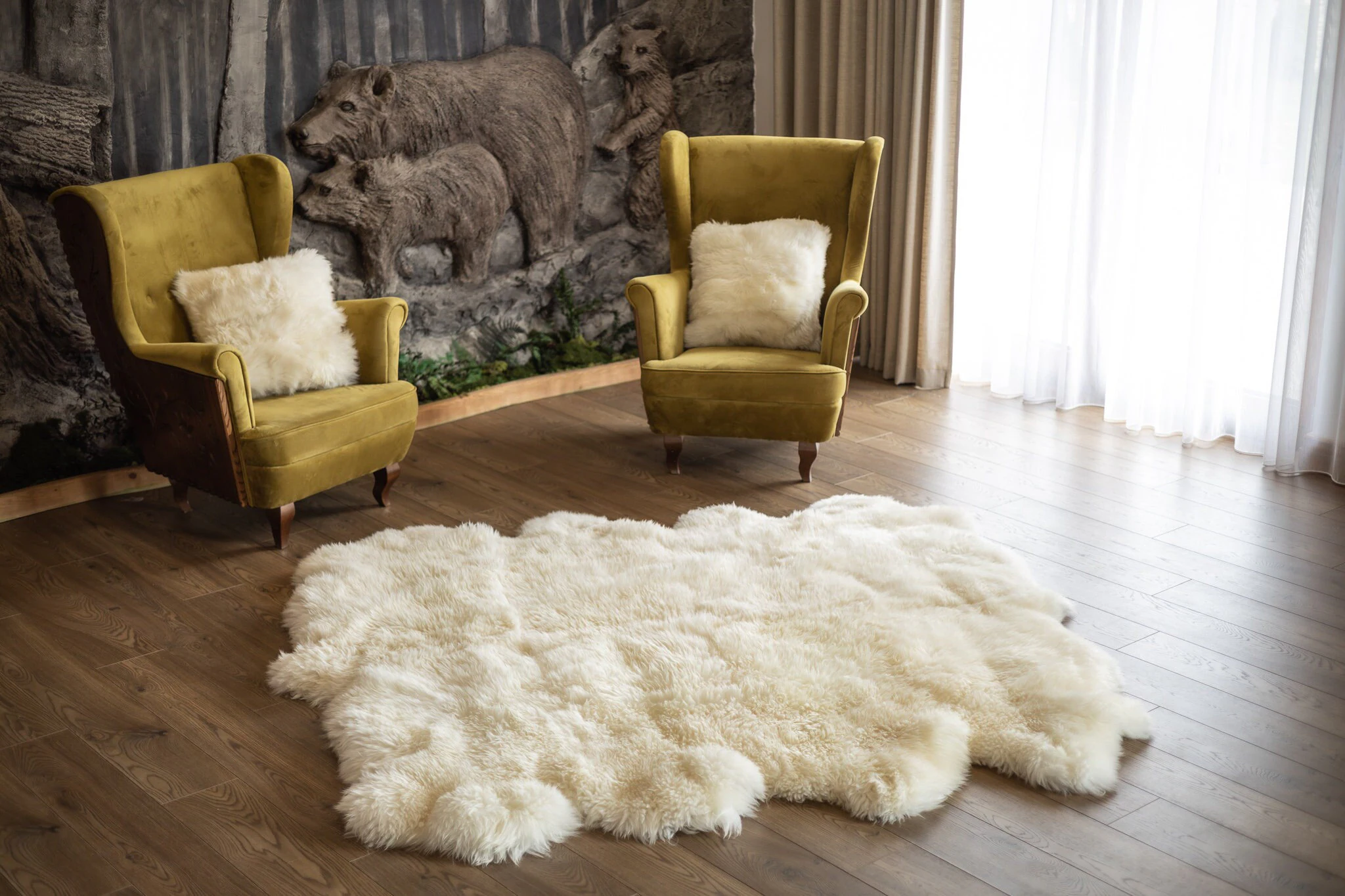 A long-curled white Mongolian wool throw draped over a neutral linen sofa while a hand gently brushes the curls with a wide-tooth comb, natural window light