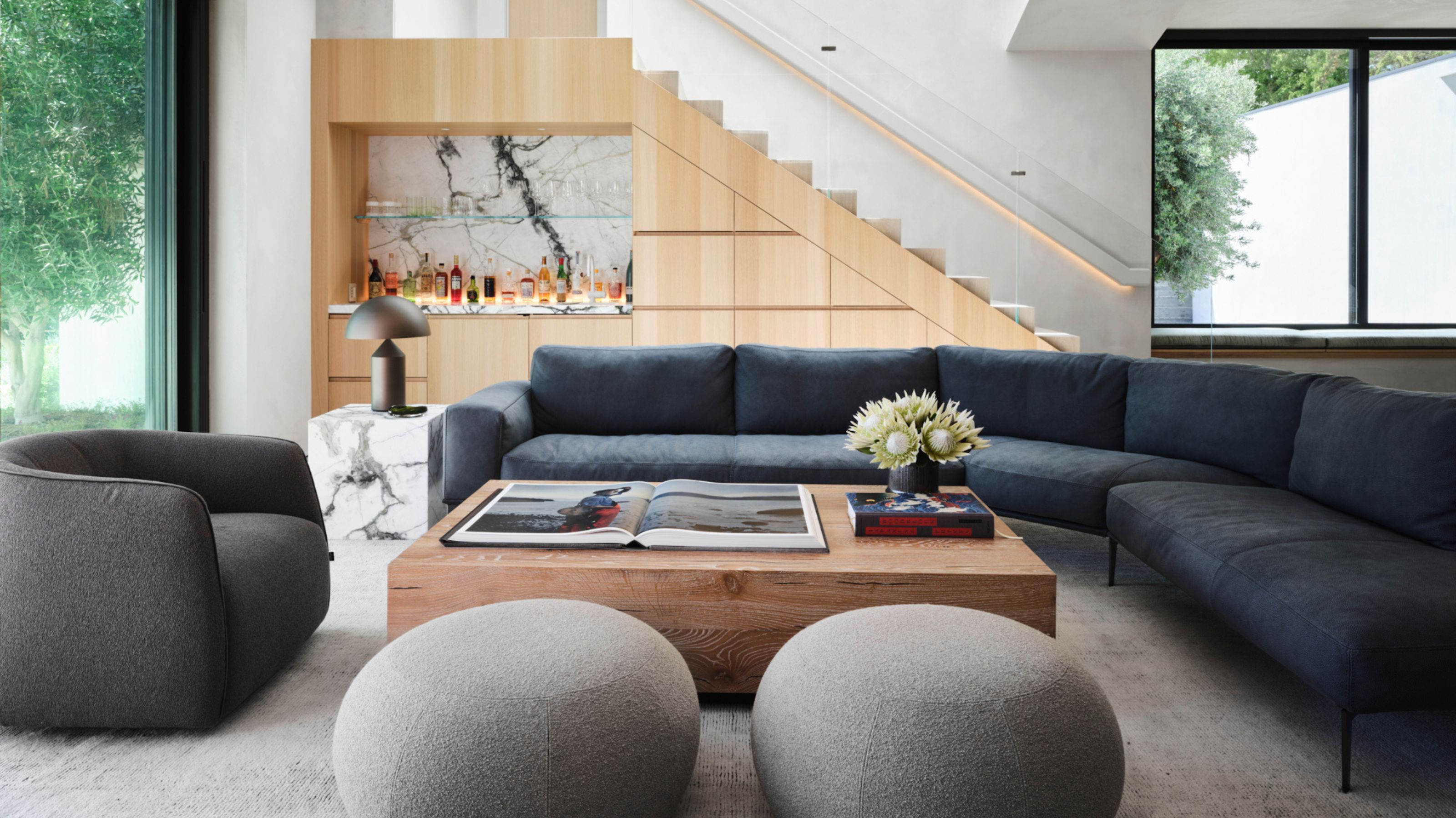 A modern sectional sofa on a light hardwood floor with a visible gap between the two pieces in a bright living room, natural daylight photography