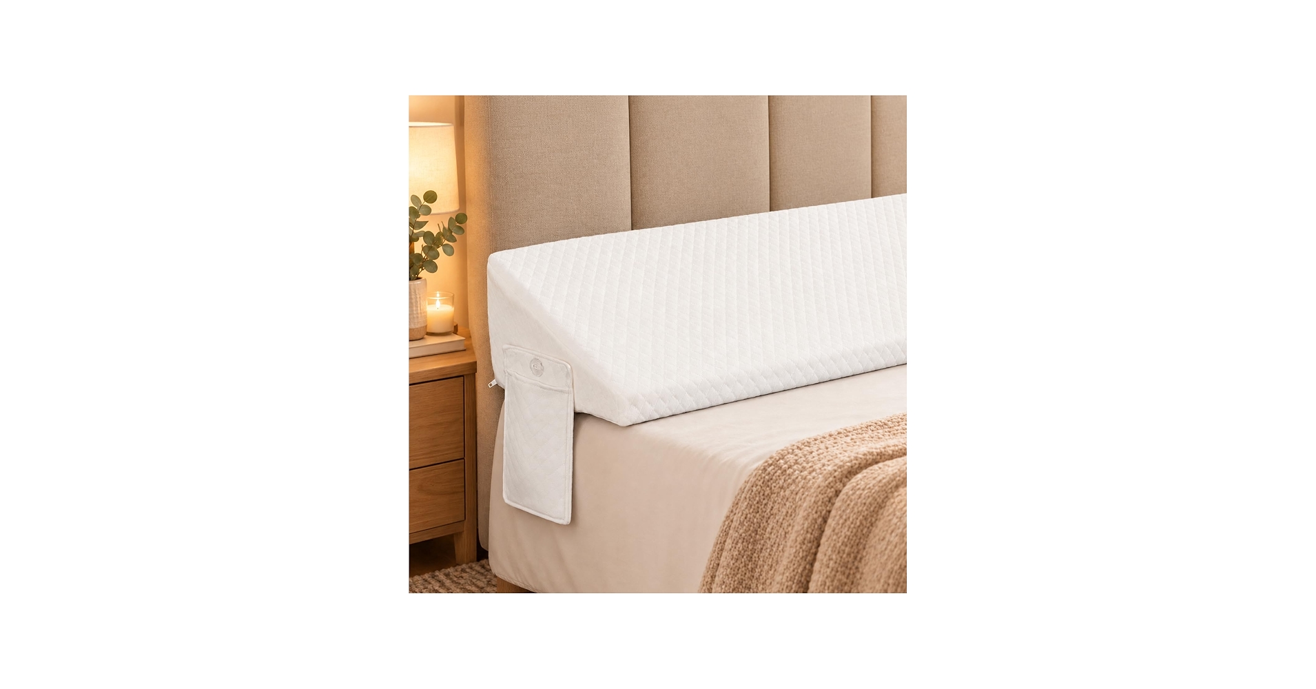A neatly made bed with a light beige fabric upholstered headboard and a visible narrow gap behind the pillows where a phone could slip, photographed in a calm bedroom