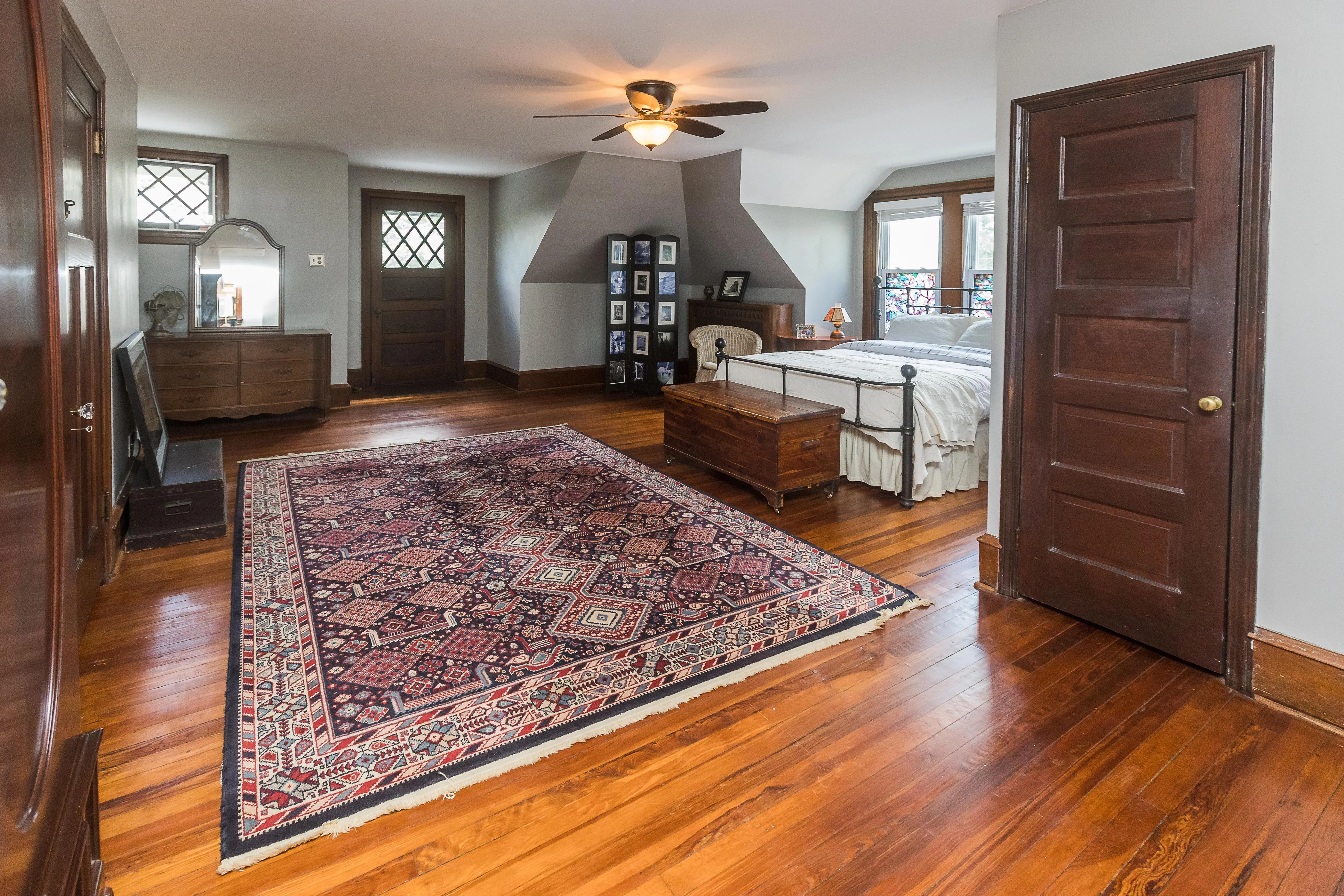 A neutral-toned area rug laid flat on a wood floor with a vacuum, baking soda, and clean white towels nearby in natural window light