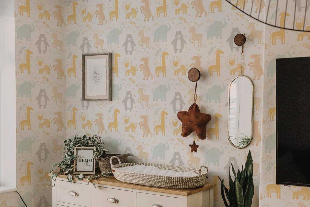 A nursery with a peel-and-stick wallpaper accent wall behind a crib, soft neutral decor and natural daylight, realistic interior photograph