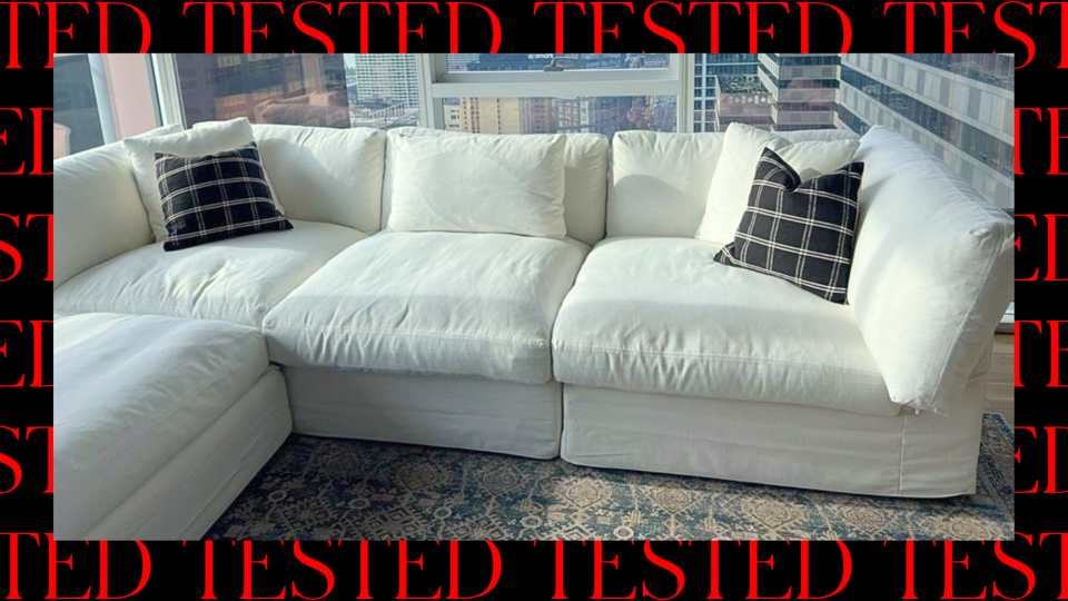 A photo of a person gently blotting a deep green velvet sofa cushion with a clean white cloth in a softly lit living room