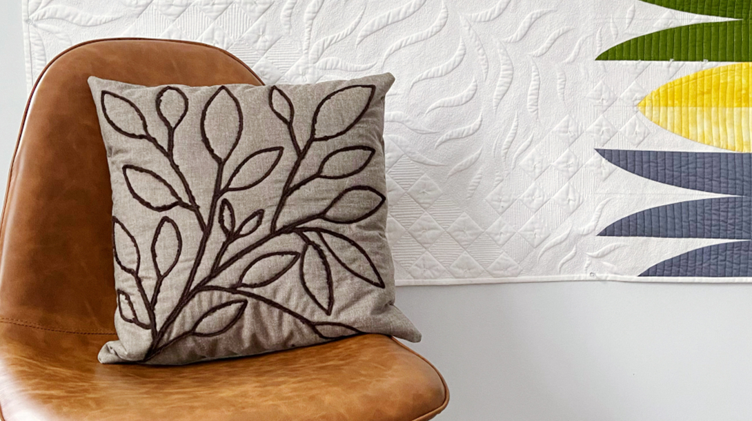 A photograph of the inside of a removable cushion cover laid flat on a table, with a piece of fusible interfacing positioned over a small weakened area of fabric