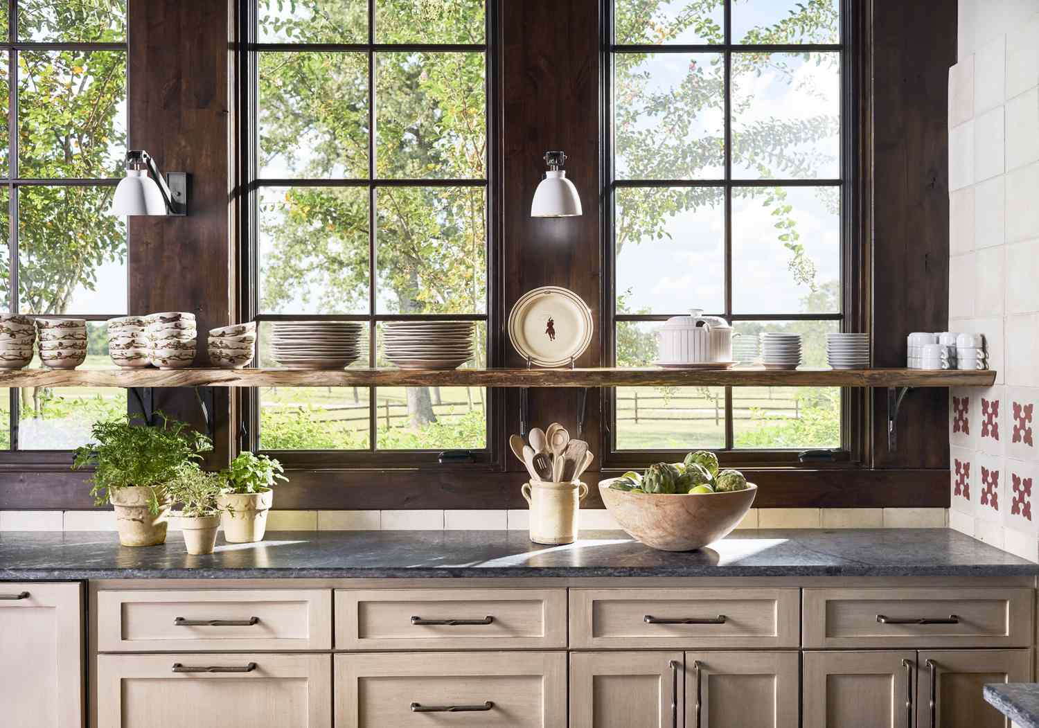 A real kitchen with a dark gray soapstone countertop in soft natural window light, showing subtle veining and a matte finish, lifestyle photography