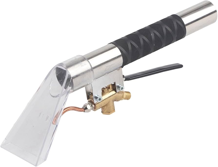 A real-life photo of a person using a vacuum upholstery attachment on a light beige armchair cushion, focusing on careful suction over a small dark soot spot