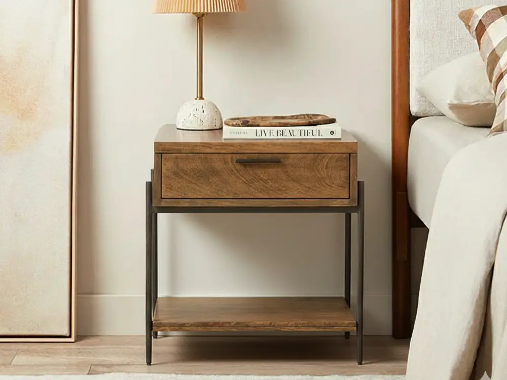 A real photo close-up of a vintage wood nightstand corner showing subtle sheen and grain, with soft lamp light highlighting the finish texture