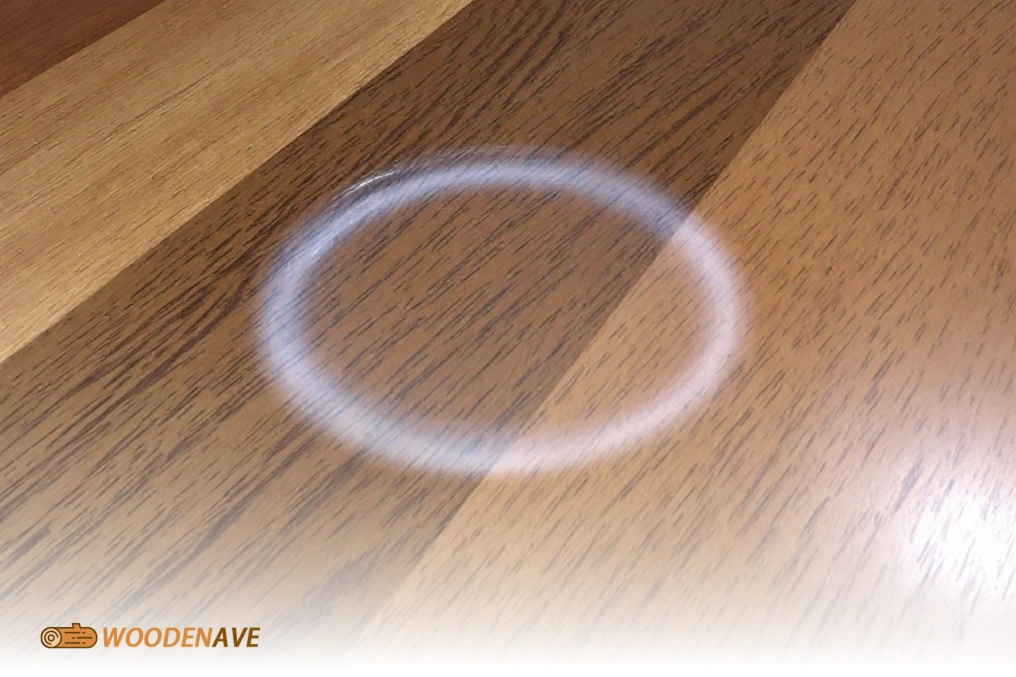 A real photo of a small dollop of mayonnaise being spread over a white water ring on a wooden tabletop with a soft cloth, warm kitchen lighting