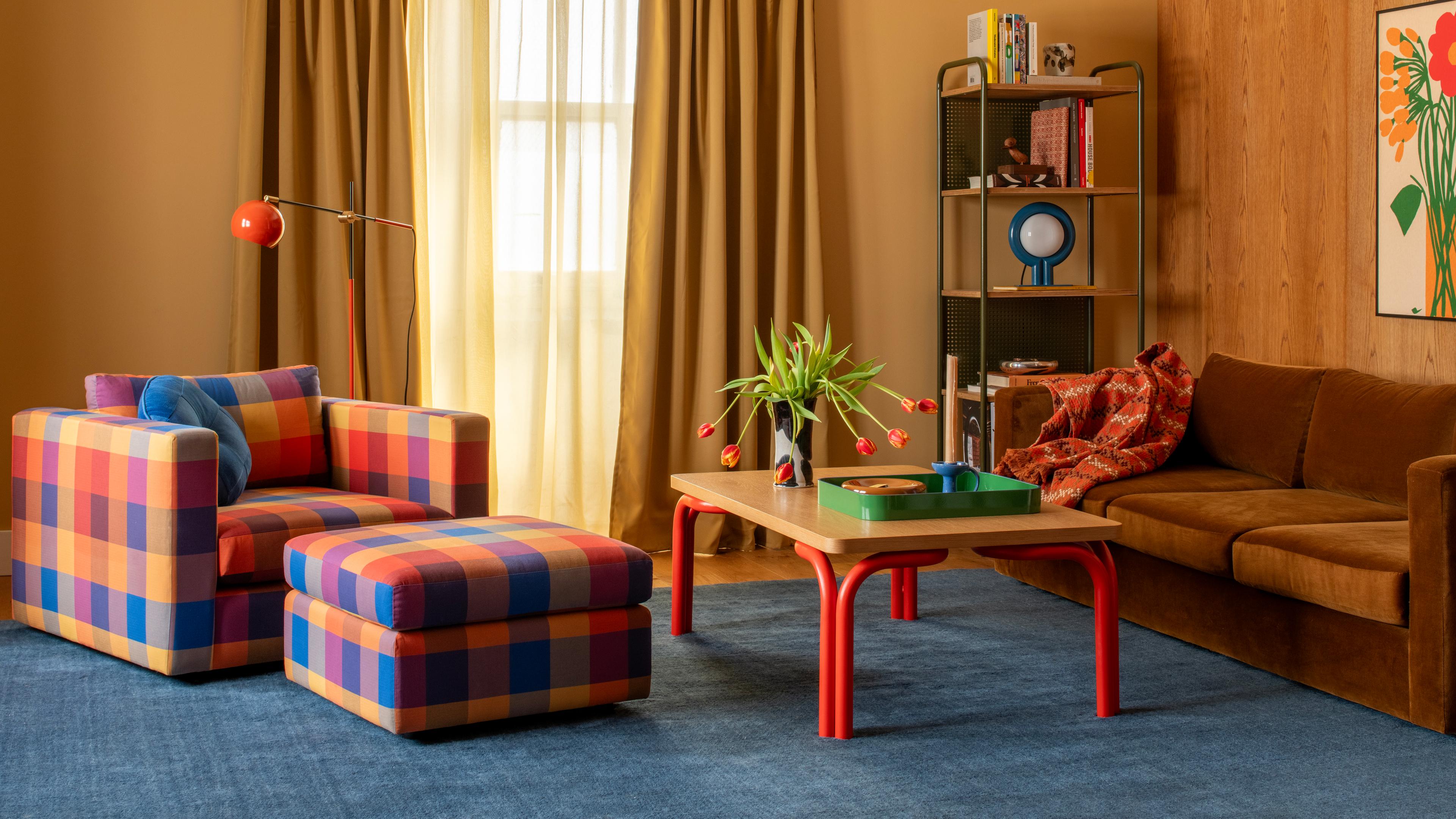 A real photo of a studio apartment where the bed has calm neutral bedding and the living area uses warmer accent pillows and throws, visually separating the zones without walls