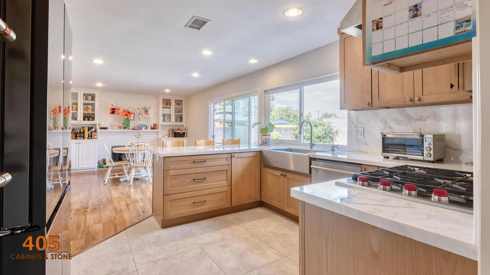 A real photo of clean, light-colored kitchen cabinets in warm natural daylight, with a soft sheen and no visible smudges around the handles