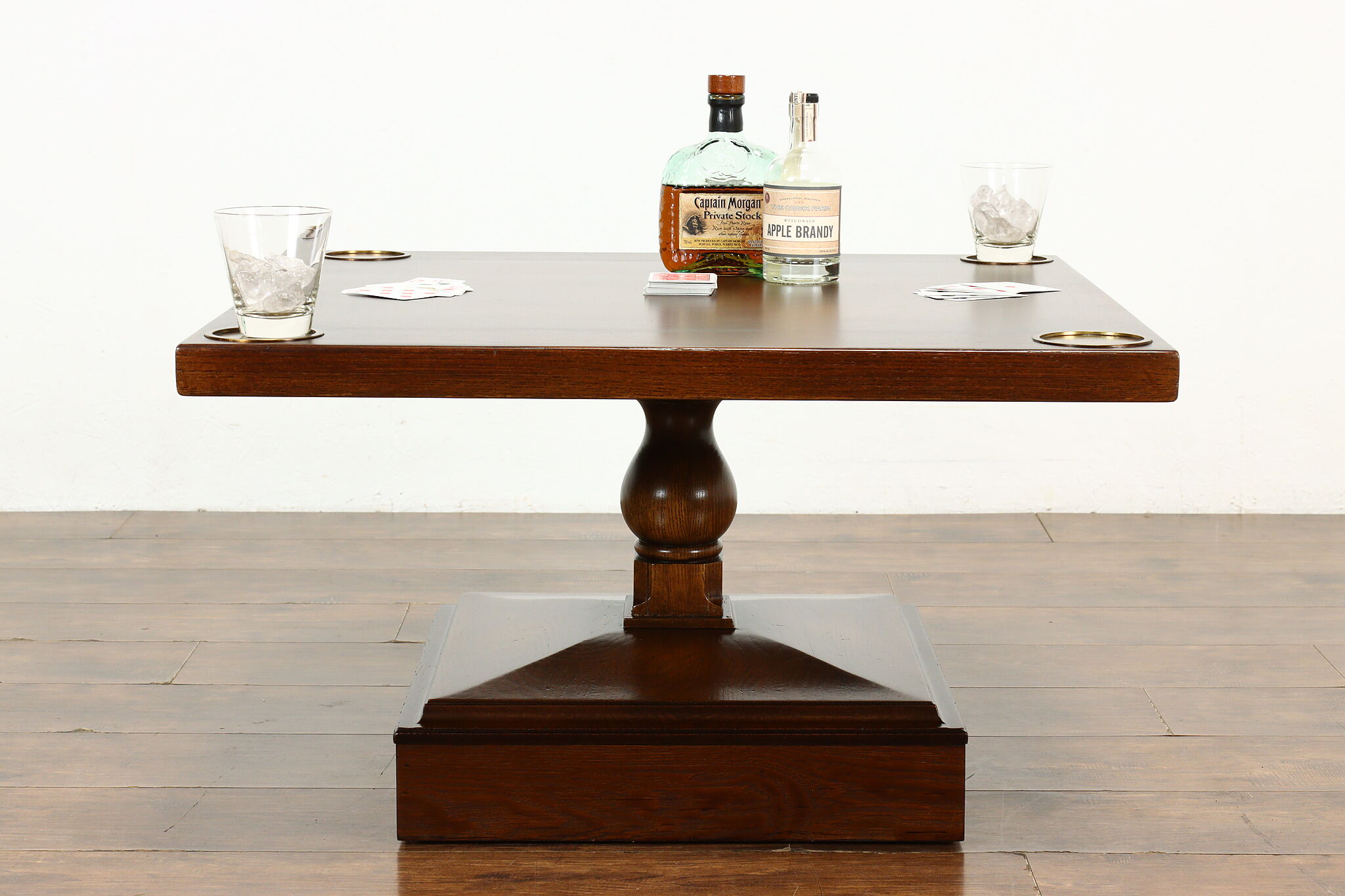 A real photograph of a wood coffee table styled with a small brass tray, a ceramic mug resting on a coaster, and soft linen textiles in a cozy living room