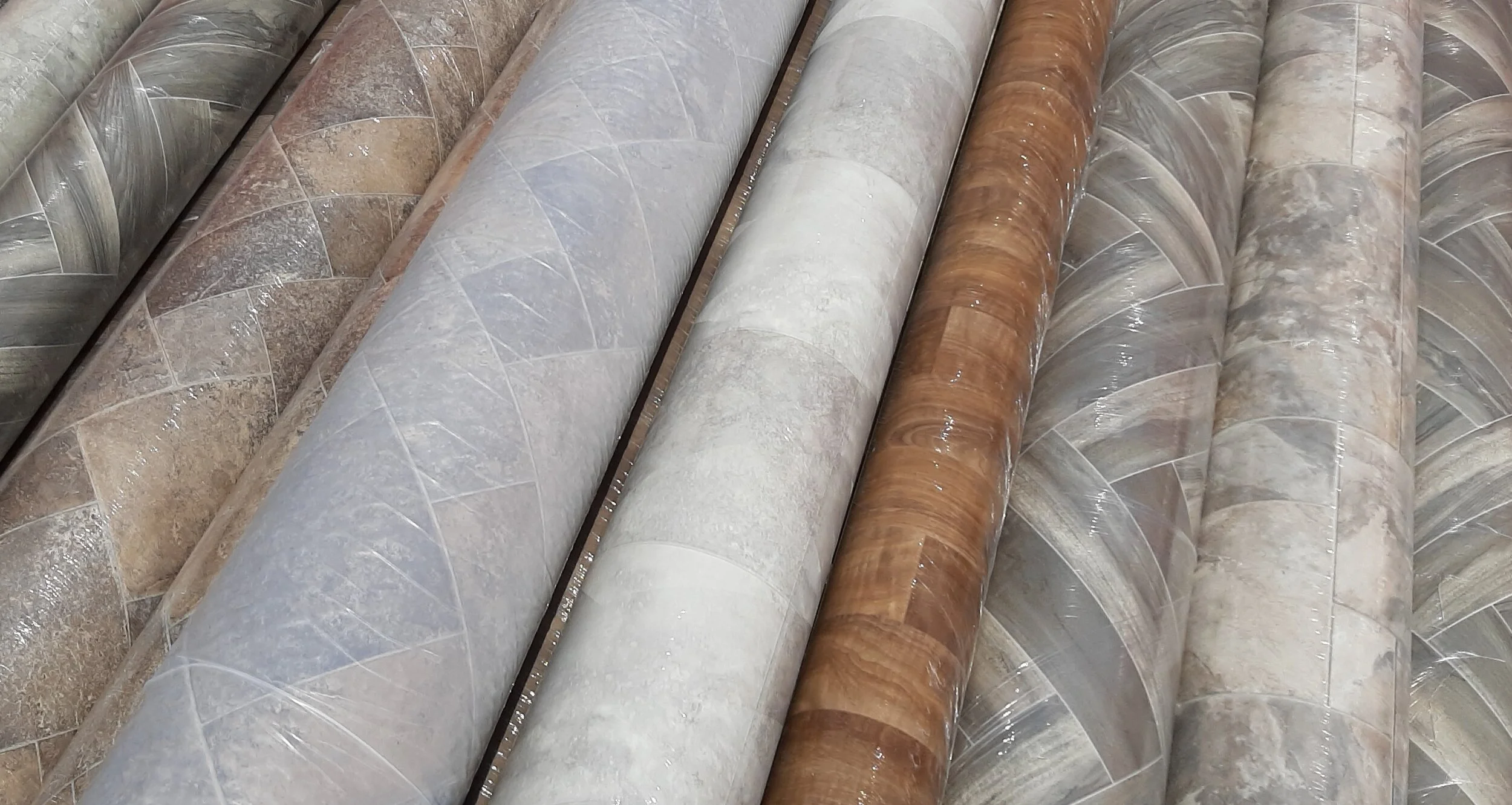 A rolled sheet of vinyl flooring on a subfloor during a home renovation
