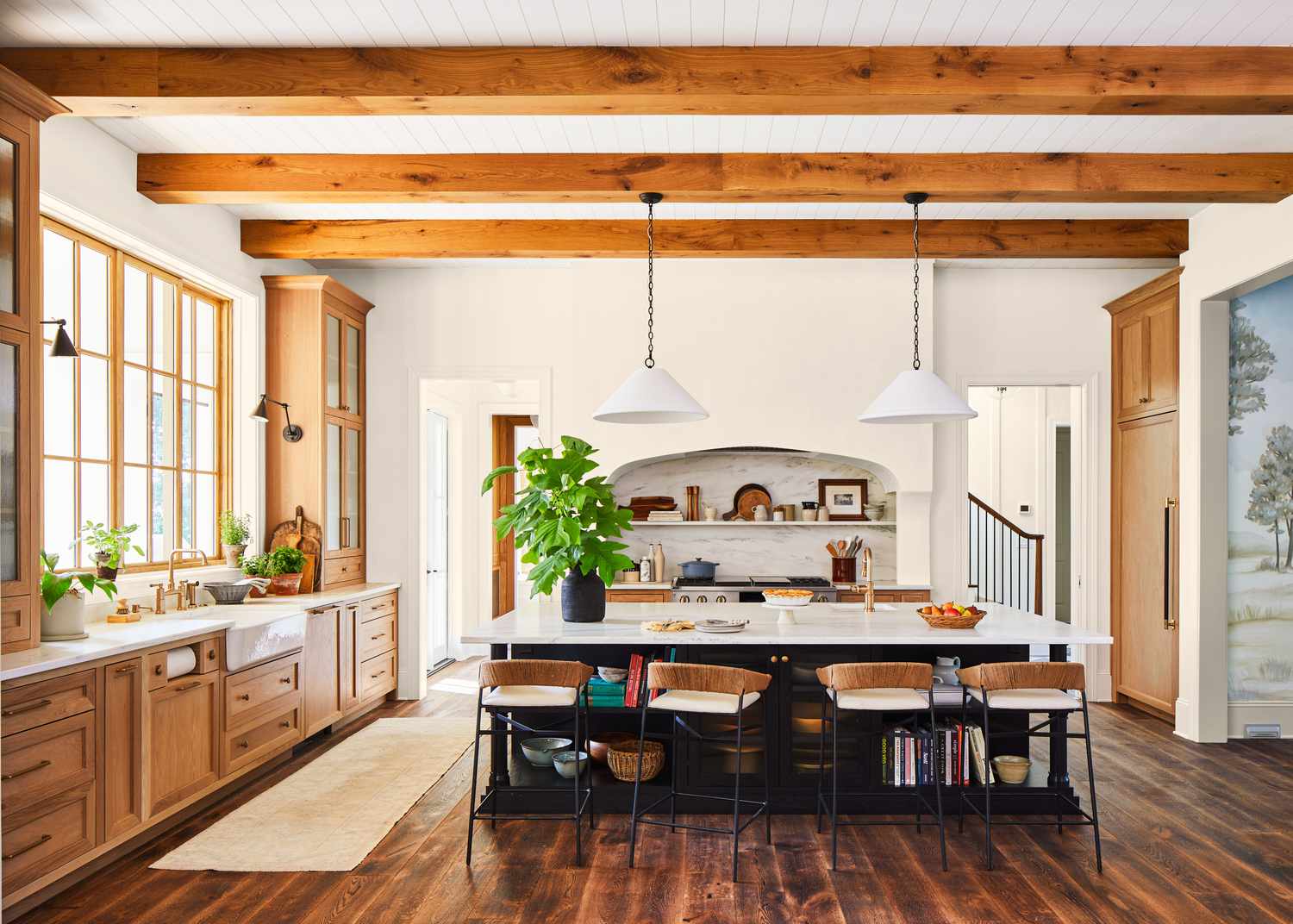 A small dining room with a low ceiling painted warm off-white, light neutral walls, a vintage brass pendant, and daylight from a window, realistic interior photography style