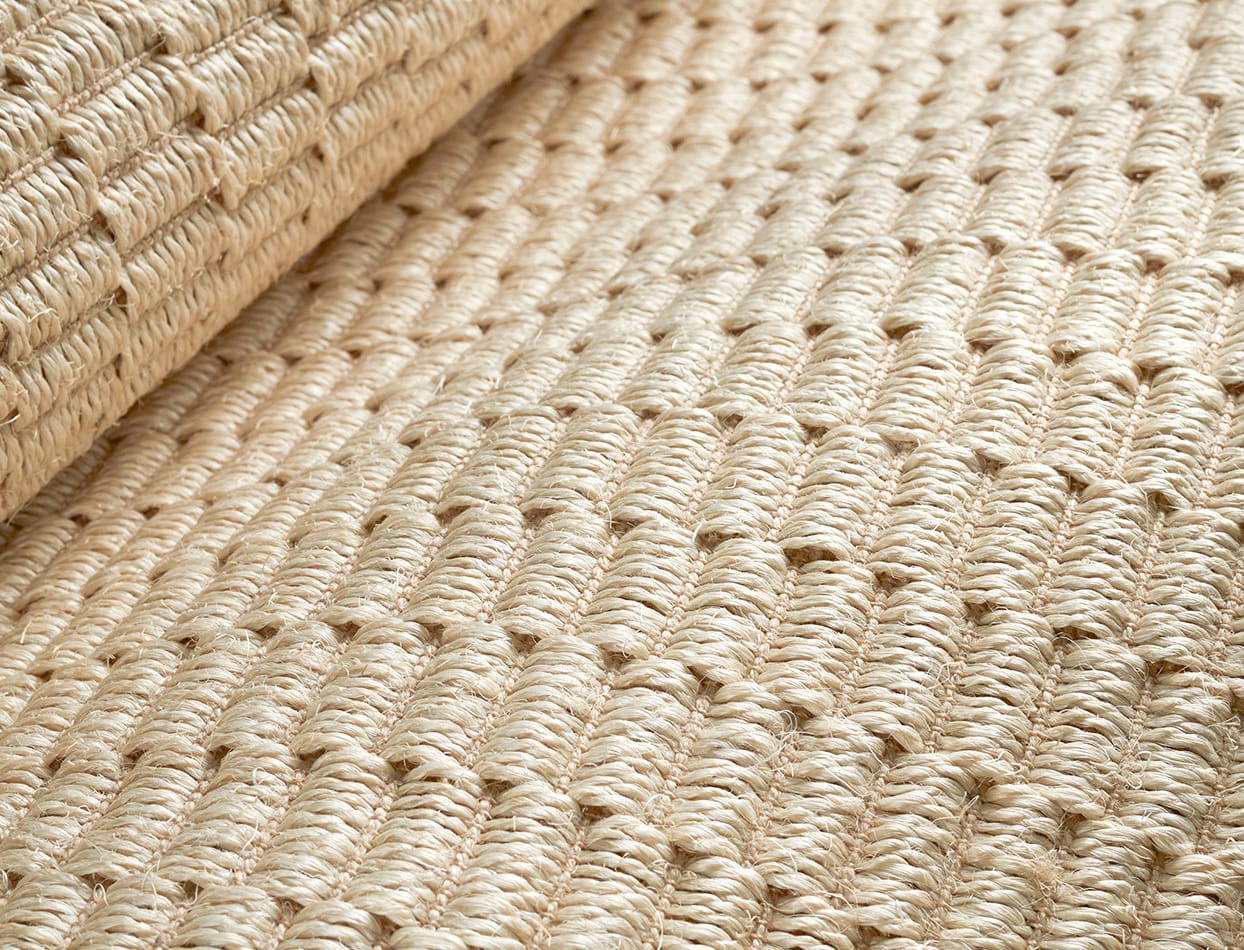 Close-up of a sisal rug weave showing thick natural fibers and texture, highlighting the tight braided structure