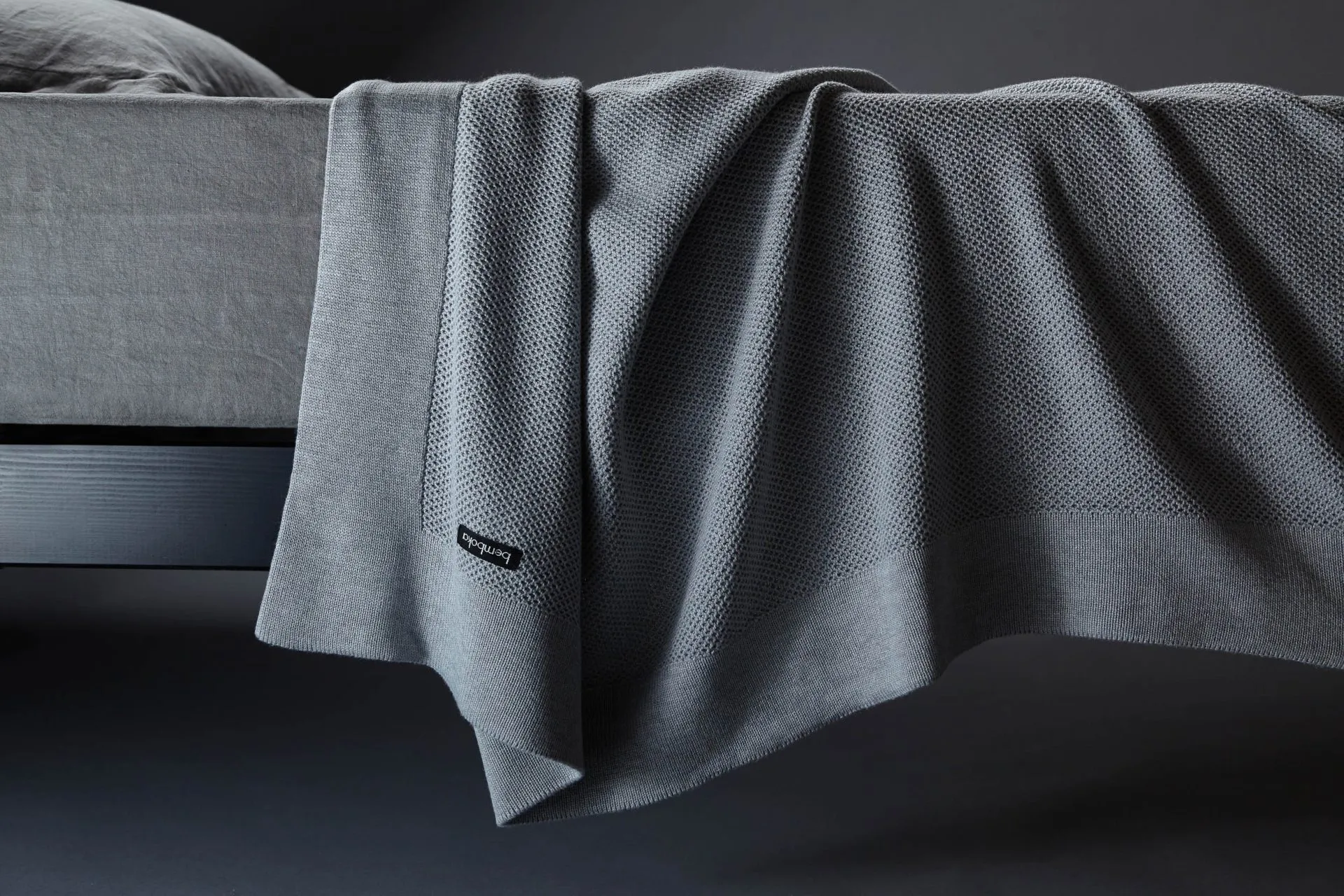 Close-up of two throw textures, one matte woven linen and one smooth fleece, side by side