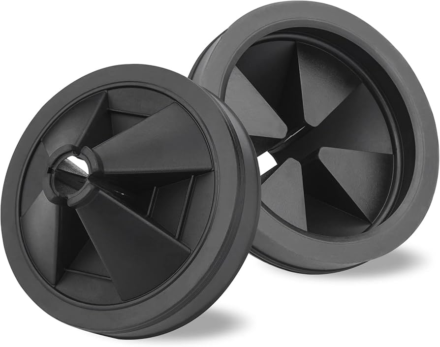 Close-up photo of a hand using a toothbrush with dish soap to scrub the underside of a rubber garbage disposal splash guard in a kitchen sink