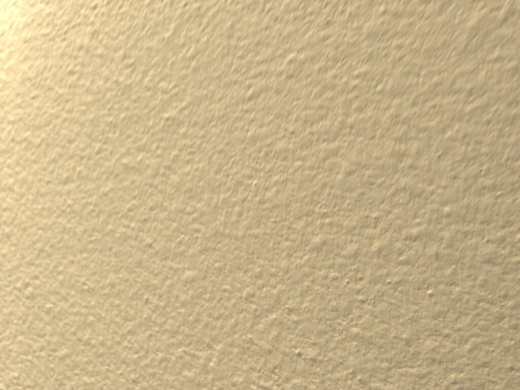 Close-up photograph of a painted drywall surface with subtle orange peel texture in warm indoor light