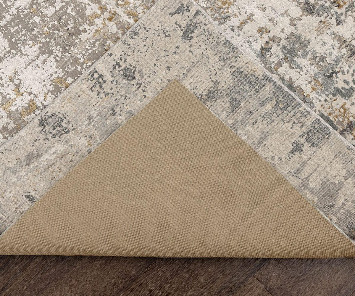Hands lifting the corner of an area rug to inspect the backing and binding along the edge